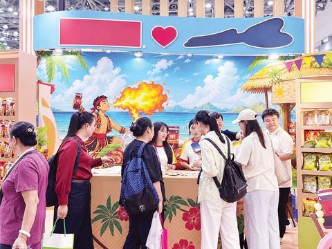 圖為參觀者在菲律濱企業上好佳（Oishi）的展位上挑選冰箱貼等小禮品。（本報南寧傳真）