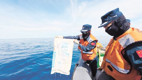 中國海警東安艦編隊在仁愛礁附近海域打撈垃圾。（央視新聞截圖）