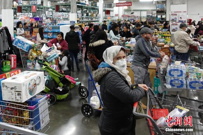 当地时间3月13日，位于美国纽约皇后区的一家大型超市，民众排队购买物资。