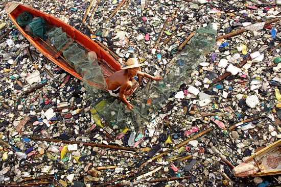 一名男子劃過這片漂浮垃圾，其中大部分是輕質塑料、橡膠和苯乙烯——這些漂浮垃圾都需要一段很長的時間才能分解，並對所有生命構成威脅。(Gregorio