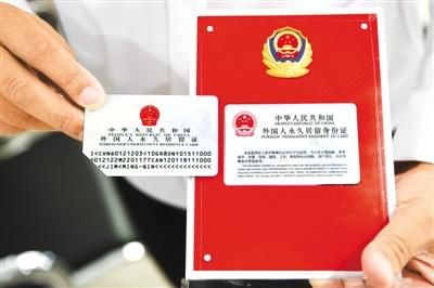 2017年6月16日，2017版外国人永久居留身份证启用。图为在北京市公安局出入境管理局中关村外国人服务大厅，一位外籍人士展示取得的2017版外国人永久居留身份证（右）与旧版的区别。