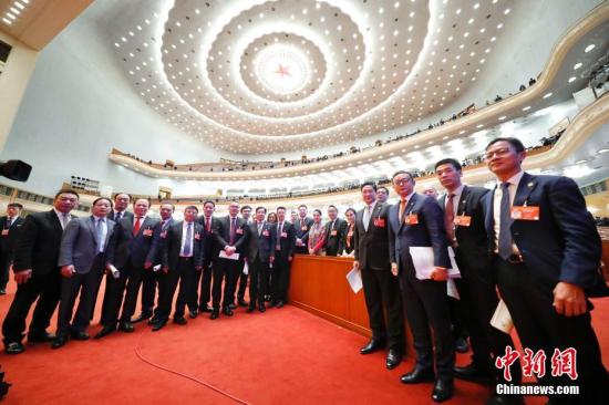 3月13日，中国人民政治协商会议第十三届全国委员会第二次会议在北京人民大会堂举行闭幕会。图为受邀列席会议的海外侨胞在闭幕会后合影留念。中新社记者