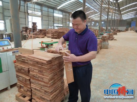 图为张廷江在他的红木工厂中工作。