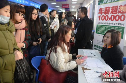 资料图：2月15日，山西太原，春节后首场高校毕业生招聘会开场，图为众多求职者被一家公司的高薪待遇吸引。韦亮