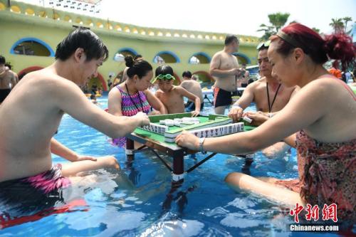 资料图：2017年8月2日，重庆洋人街一水上乐园举行夏季消暑活动，其中水中玩麻将吸引不少游客参与。陈超