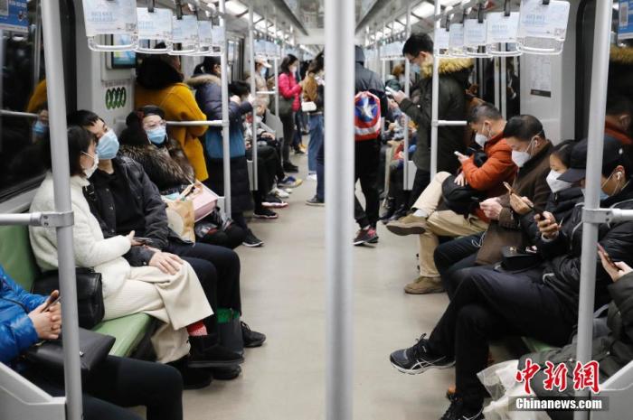 2月28日，乘客戴着口罩乘坐上海地铁出行。近日，随着上海企业全面复工，上海地铁客运量回升，高峰时段车厢满载率平均在五成左右。