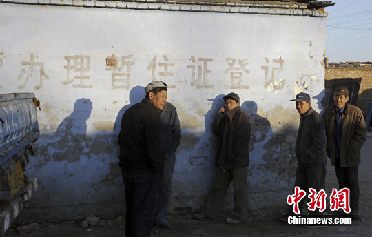 2015年2月15日消息，《关于全面深化公安改革若干重大问题的框架意见》及相关改革方案已经中央审议通过，即将印发实施。图为北京一处村庄墙上印着“办理暂住证登记”的红字。中新社发