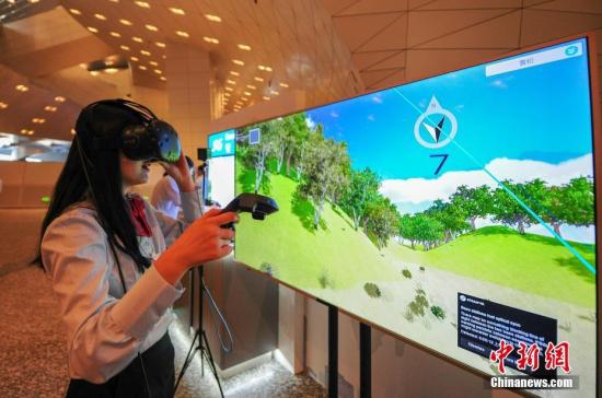 7月1日，2019夏季达沃斯论坛上，体验者在体验5G混合现实智能沙箱VR部分。中新社记者