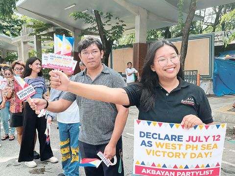 Akbayan黨團組織週五在計順市橢圓形道路舉行「西菲律濱海勝利日」紀念活動，以「旗海」形式向駕駛人與行人分發國旗。