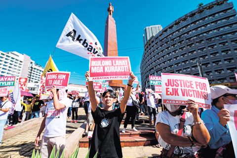 抗議者於2月23日，即國際刑事法院對前總統杜特地涉嫌危害人類罪案舉行預審聽證會的今日，在計順市的一場集會中高舉標語牌。