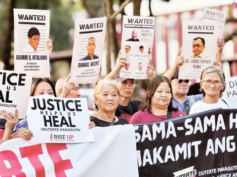 法外處決受害者家屬高舉前總統杜特地在國際刑事法院反人類罪案件中據稱的共犯照片。在聽取檢辯雙方陳述後，該團體表示，他們現在確信案件將進入審判階段。