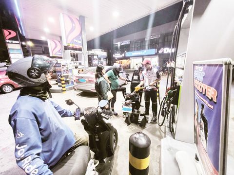 3月23日晚間，在新一輪分階段油價調漲生效前數小時，汽車和摩托車在計順市一座加油站加油。能源部表示，自3月24日起，汽油價格可能每公升上漲6.47披索，柴油上漲11.88披索，煤油上漲13.66披索。