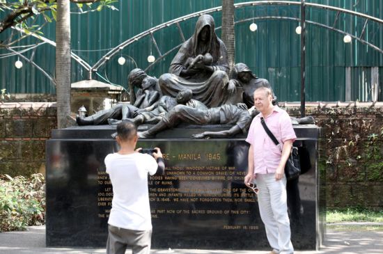 一名外國遊客於週二在馬尼拉王城區的「1945年馬尼拉二戰死難者紀念碑」前拍攝紀念照。